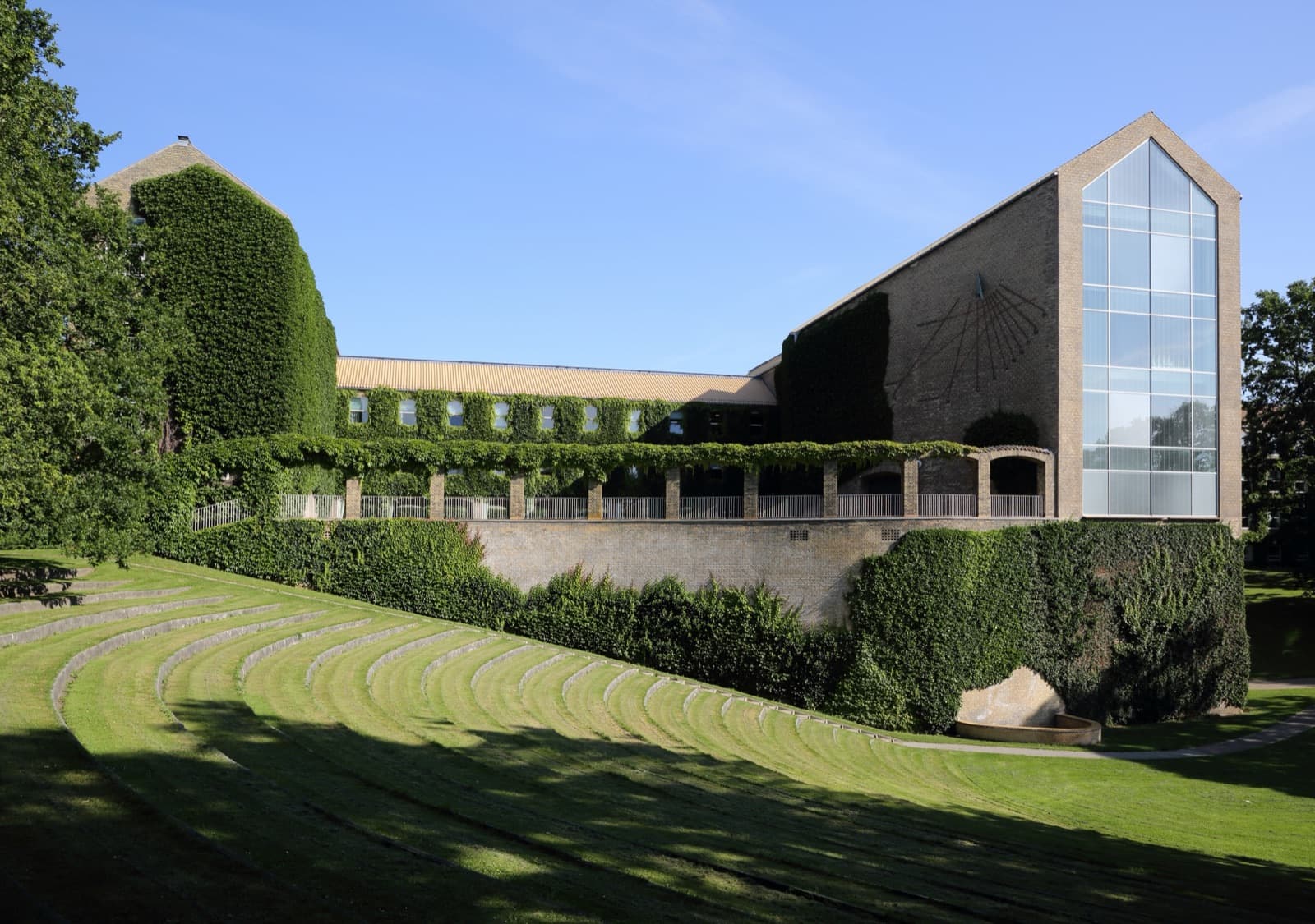 Das efeubewachsene Hauptgebäude und das Rasenamphitheater im Universitätspark Aarhus
